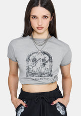Woman wearing a gray graphic t-shirt with black design on a white background